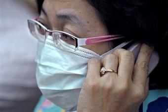 A Thai health official wears a protective mask during a press conference in Bangkok.(AFP/Pornchai Kittiwongsakul)