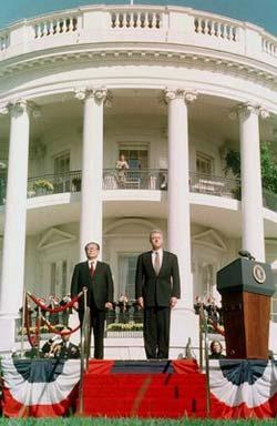 Chinese President Jiang Zemin (L) and US President Bill Clinton stand in front of the White House's South Portico during welcoming ceremonies for Jiang in Washington in this October 29, 1997 file photo. [Agencies]