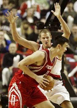 Houston Rockets center Yao Ming, left, makes a move to the basket against Portland Trail Blazers center Joel Pryzbilla during NBA second half basketball action in Portland, Ore., Friday, Jan. 25, 2008. Yao Ming scored 11 points as the Rockets beat the Blazers 89-79.(AP Photo/Don Ryan) 