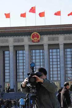 A TV cameraman works in front of the Great Hall of the People in Beijing, capital of China, March 3, 2008. (Xinhua Photo)