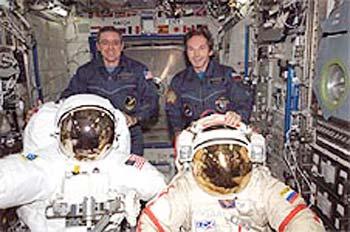 Astronaut Bill McArthur (left) and cosmonaut Valery Tokarev display American (left) and Russian spacesuits.(Image Credit: NASA)