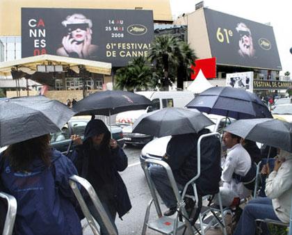 Cinema fans with umbrellas take shelter from the rain as they guard their spots the day before the opening of the 61st Cannes Film Festival May 13, 2008. Brazilian director Fernando Mereilles will open this year's Cannes film festival May 14 with the English-language film "Blindness" starring Julianne Moore, Danny Glover and Gael Garcia Bernal.  (Xinhua/Reuters Photo)