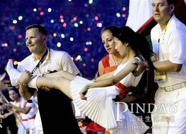 Two Polish physician and one athlete are helping a girl who suddently collapsed during the opening ceremony of Beijing Olympic games.