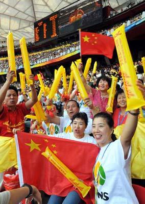 Members of the cheering squad organized by the Beijing federation of trade unions cheer for athletes during the men's marathon event of the Beijing 2008 Olympic Games at the National Stadium, also known as the Bird's Nest, in Beijing, capital of China, Aug. 24, 2008. About 150,000 workers from Beijing joined cheering squads during the Beijing Olympic Games. (Xinhua/He Junchang)