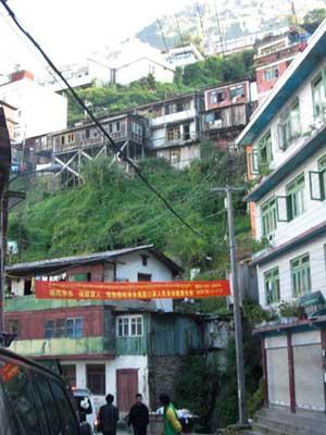 Looking up from street level you can see houses rising up on the mountain in the border city of Zhangmu. [CRIENGLISH.com]