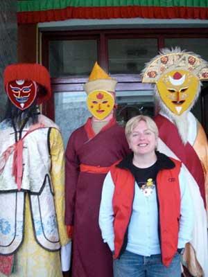 CRI reporter Julianne Page stands in front of an impressive display of typical traditional Tibetan costumes.[Photo:CRIENGLISH.com]