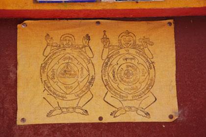 A Tibetan Buddhist religious pictogram found tacked onto many of the doors in the Shigatse hutongs. [Photo: CRIENGLISH.com]