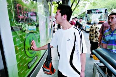 7月5日，在的Dongshixikou巴士站，一个人把他的手放在一个“快乐的公共汽车候车亭快快乐乐。”