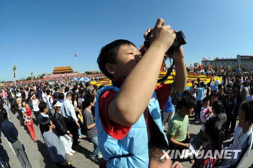 On October 3, a boy sitting on his parent's shoulders was taking in the splendid views of the Tiananmen Square. On the same day, there were countless visitors in the Square from all over China. They were all happily walking around and taking pictures in the square to celebrate the National Day holiday. On October 2, visitors crowded Tiananmen Square.