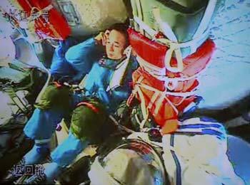 This video grab, taken on September 26, 2008 at the Beijing Space Command and Control Center in Beijing, shows Chinese astronaut Jing Haipeng sitting in Shenzhou VII while two other astronauts are busy assembling the indigenous Feitian extra-vehicular activity (EVA) suit. Astronauts aboard the Shenzhou VII spacecraft, China's third manned spaceship, began to assemble the suit and test its obturation and functions Friday in preparation for the first spacewalk, planned for Saturday afternoon. [Xinhua]