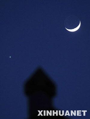 A crescent moon (R) is seen close together with the planet Venus in the sky over northwest China's Yinchuan city, Jan. 30, 2009.(Xinhua/Wang Peng)