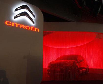 A new concept car is about to be unveiled next to the new Logo of French car maker Peugeot-Citroen during a news conference in Paris, February 5, 2009. (Xinhua/Reuters Photo)