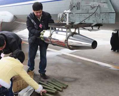 Workers equip the aircraft with catalystic silver iodide for the mission of artificial rainfall operations at Xinzheng International Airport in Zhengzhou, capital of central China's Henan Province, Feb. 8, 2009. A couple of 