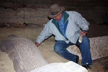 A handout picture released by the Egyptian Supreme Council for Antiquities (SCA) shows SCA Secretary General Zahi Hawas clearing dust off a sarcophagus found in Sakkara. Egyptian archaeologists have discovered dozens of mummies and several stone and wood sarcophagi south of Cairo in a pharaonic tomb estimated to be 4,300 years old.(Xinhua/AFP Photo)