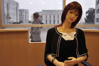 A woman walks by a Japanese-made robot receptionist named Ms. Saya at Ben-Gurion University of the Negev in the southern city of Be'er Sheva in this picture taken February 5, 2007.(Xinhua/Reuters Photo)