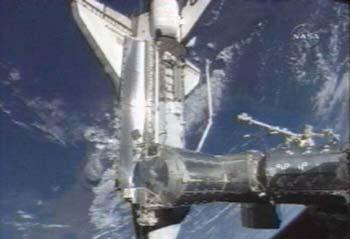 A camera outside the International Space Station reveals the shuttle Discovery just after its March 17, 2009 docking during the STS-119 mission. Credit: NASA TV.