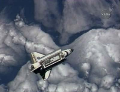 The Space Shuttle Discovery is backdropped against the clouds prior to docking with the International Space Station in this image from NASA TV March 17, 2009. (Xinhua/Reuters Photo)
