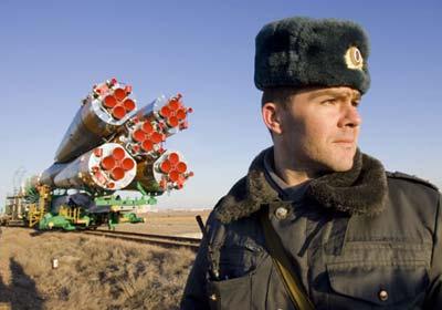 A Russian policeman guards the Soyuz TMA-14 spacecraft as it is transported to its launch pad at Baikonur cosmodrome March 24, 2009. The spacecraft is scheduled to take U.S. entrepreneur Charles Simonyi, Russian cosmonaut Gennady Padalka and U.S. astronaut Michael Barratt to the International Space Station (ISS) on Thursday.(Xinhua/Reuters Photo)
