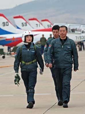 Pilot trainee Yu Xu (L) walks with coaches after a flight test in China, March 29, 2009. China's first batch of female jet fighter pilots were conferred the rank of lieutenant on April 2. (Xinhua Photo)