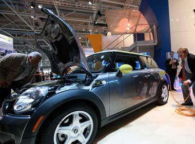 Visitors look at an electric car during the 