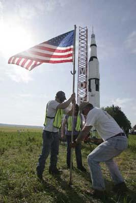 Launch ground crew members erect a U.S. Flag in front of rocket builder Steve Eves' one-tenth scale Saturn V rocket (rear) in Price, Maryland during the early morning hours of April 25, 2009. The 36 foot high rocket, which was a three-year project costing approximately 25,000-30,000 U.S. dollars to build, is the largest model rocket ever successfully launched. Eves' rocket commemorates the 40th anniversary of the July 16, 1969 launch of the United States Apollo 11, which put the first man on the moon. (Xinhua/Reuters Photo)