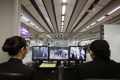 Staff members check the temperature of passengers with the help of machines at Hong Kong International Airport in Hong Kong, south China, April 27, 2009. Hong Kong Special Administrative Region has taken measures to contain the possible spread of swine flu. (Xinhua Photo)