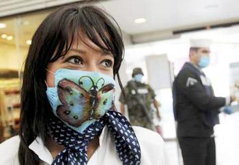 Cristina Trejo, who works at the Mexicana airlines counter, wears a surgical mask with a butterfly painted by herself at Mexico City's international airport Benito Juarez April 27, 2009.(Xinhua/Reuters Photo)