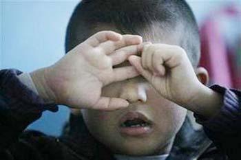 An autistic child reacts during a therapy session at the Stars and Rain School for autistic children in Beijing March 23, 2009. [Agencies]
