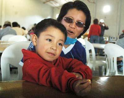 Four-year-old Edgar Hernandez (L) who has recovered from the A/H1N1 flu influenza recently, and his mother rest in a free dining room at his hometown in Veracruz state in Mexico May 2, 2009. Hernandez is the first patient who was infected by the A/H1N1 flu influenza in Mexico. (Xinhua Photo)