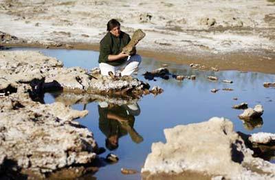 Gustavo Lara, Director of Culture of the town of Roque Perez, holds a fossil bone of a megatherium, a kind of large ground sloth, at an excavation site on the outskirts of Roque Perez, some 135 km (84 miles) south of Buenos Aires, May 6, 2009. Fossil bones of nine glossopteris, a glyptodont, the nearly complete skeleton of a megatherium and a head of a stegomastodon dated from the Pleistocene, the epoch from 1.8 million to 10000 years ago, were found by paleontologists in the sediments of the Salado River due to a drought that has been affecting the area for months, local media reported. (Xinhua/Reuters Photo)