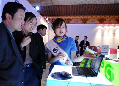 An attendant introduces the 3G service to visitors in Lhasa, capital of southwest China's Tibet Autonomous Region, May 9, 2009.  (Xinhua
