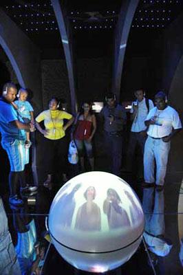 Visitors listen to the radio guide beside a round screen displaying the development of telecommunications in the Museum of Telecommunications in Brazilian city of Rio de Janeiro, May 9, 2009. The museum of Telecommunications is located in a culture center building in Rio de Janeiro. The museum, transformed and decorated since 1999, provides audio, vedio and other multimedia to vividly introduce the development of telecommunications in Brazil. (Xinhua photo)