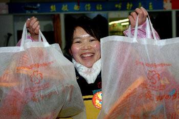 A supermarket worker is showing environment-friendly shopping bags which have been adopted for two years in Lhasa, photo from Xinhua, January 10, 2008.
