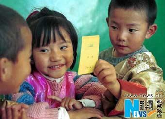 Kids in the Tibet Autonomous Region Experimental Kindergarden are learning 3 languages (Tibetan, Chinese, English) with a card, photo from Xinhua in March, 2001.