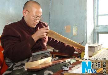 A monk, who is from the Tibetan Buddhism Printing House of the TAR Section of the Buddhism Association of China, is working on the publication of "Tibetan Tripitaka", photo from Xinhua on November 9, 2003. From 1993 to 2003, 7.22 million yuan has been invested in publishing 120 volumes of "Tibetan Tripitaka".